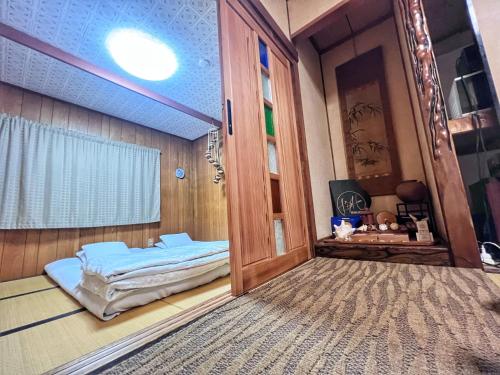 een kamer met een deur en een bed in een kamer bij Bighem Maison in Izumi-Sano