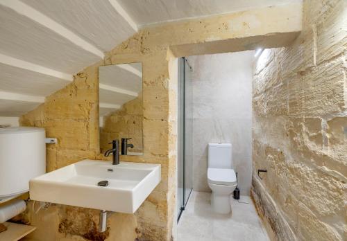 een badkamer met een wastafel en een toilet bij Seafront Traditional Maltese Townhouse Balluta Bay in Sliema