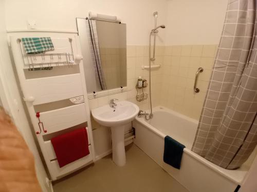 y baño con lavabo, bañera, aseo y lavamanos. en Relais GLASSDELL, en Freyming-Merlebach