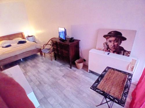un dormitorio con una cama y una pintura de un hombre en Relais GLASSDELL, en Freyming-Merlebach