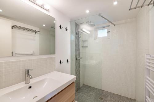 a white bathroom with a sink and a shower at Au Petit Sequoia - Appt avec vue montagne in Saint-Mamet