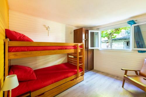 two bunk beds in a room with a window at Au Petit Sequoia - Appt avec vue montagne in Saint-Mamet