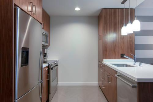 a kitchen with a stainless steel refrigerator and wooden cabinets at Downtown 1BR w Gym WD next to The Broad LAX-51 in Los Angeles