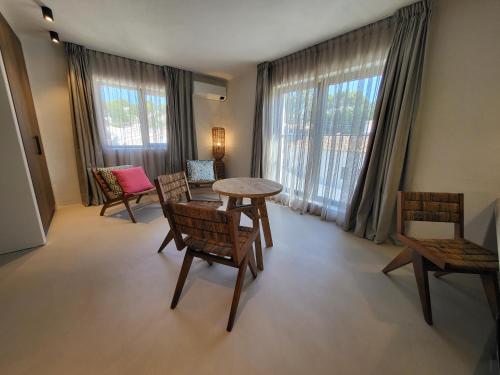 a living room with a table and chairs and windows at Boutique Hotel Los Limoneros in Moraira