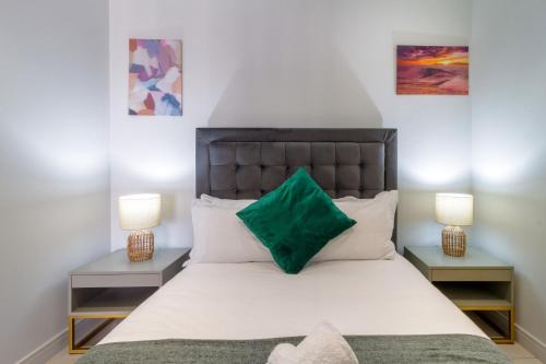 a bedroom with a large white bed with two lamps at AlimamaSpaces The Moksit Suite Ellipse in Midrand