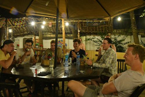 a group of men sitting around a table in a restaurant at Tulia House Backpackers in Mombasa