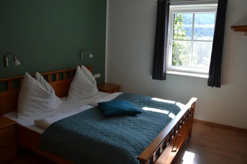 ein Schlafzimmer mit einem Bett mit einer blauen Decke und einem Fenster in der Unterkunft Ferienstadl - Hammerau in Göstling an der Ybbs