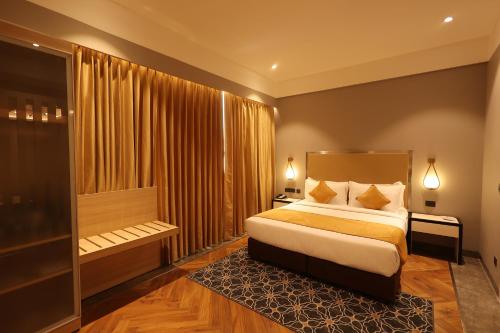 a bedroom with a bed and a large window at Hotel Polo Towers Agartala in Agartala