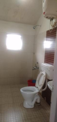 a bathroom with a white toilet and a sink at OOTY EVERGREEN COTTAGE in Ooty