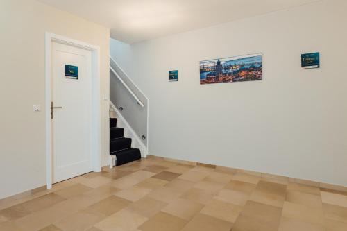 an empty room with a staircase and a door at Hanseat Apartments in Hamburg