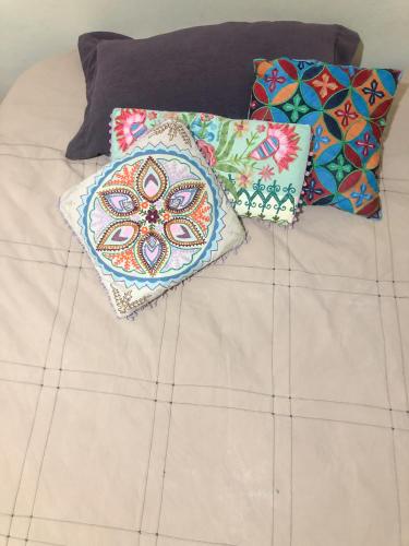 two pillows sitting on top of a bed at Quarto com varanda tipo Airbn b Vista Panorâmica Livre da Cidade in Americana