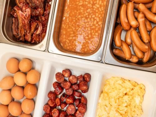 a tray of food with eggs eggs sausage and beans at Hotel Troja in Prague