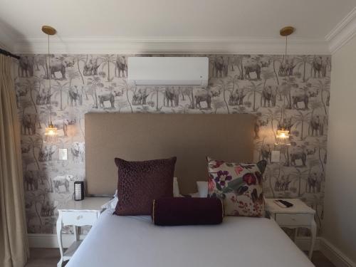 a bedroom with a bed and a wall with at Thyme Wellness Spa and Guesthouse in Cape Town
