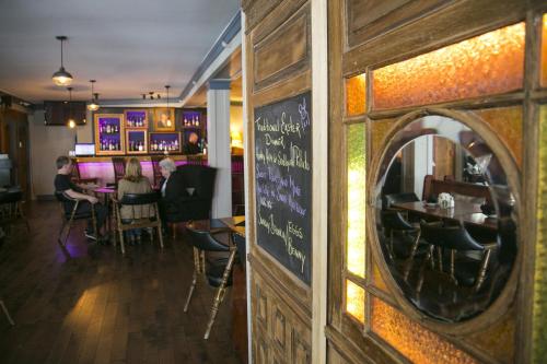 a restaurant with a chalkboard on the wall and people sitting at tables at Lanes Privateer Inn in Liverpool