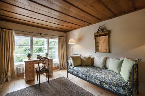 a room with a couch and a desk and a window at Garden Cottage der Villa Liechtenstein in Altaussee