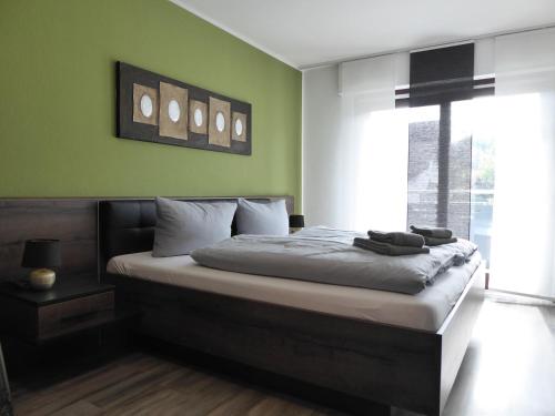ein Schlafzimmer mit einem großen Bett mit grünen Wänden in der Unterkunft Happyness Winterberg 6 Person Wifi 1 Haus in Winterberg