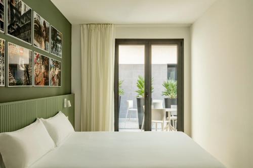 a bedroom with a bed and a balcony with a table at Europa Apartments in Hospitalet de Llobregat