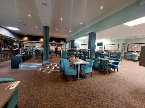 a restaurant with blue chairs and tables and a bar at Flannery's Hotel in Galway