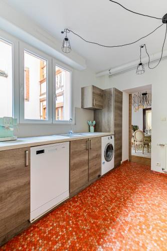 une grande cuisine avec un lave-linge et un sèche-linge. dans l'établissement Petit arc en ciel, à Strasbourg