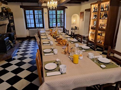 einen langen Tisch in einem Zimmer mit kariertem Boden in der Unterkunft La Rossignolerie - Cabane aux oiseaux in Chouzy-sur-Cisse