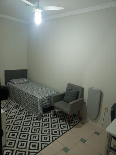 um quarto com uma cama e uma cadeira em dormitorio 4 solteiro luxuoso a 2 km de alphaville em Barueri