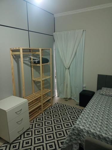 um quarto com uma cama, uma cómoda e uma janela em dormitorio 4 solteiro luxuoso a 2 km de alphaville em Barueri