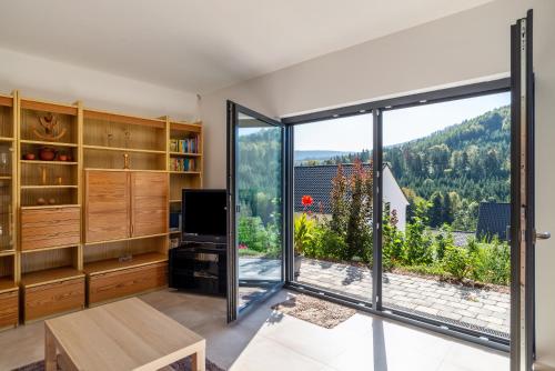 un soggiorno con porta scorrevole in vetro e una grande finestra di Ferienwohnung Rennbachtal a Bad Herrenalb