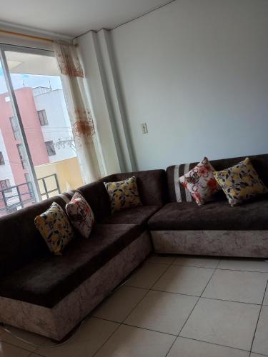 um sofá castanho com almofadas numa sala de estar em Departamento loja em Loja