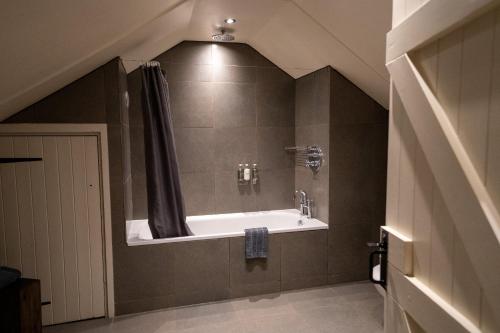 a bathroom with a bath tub with a shower at Milsoms in Dedham