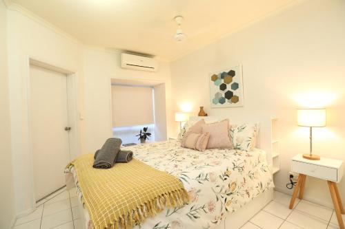 um quarto com uma cama e uma mesa com um candeeiro em 1 Bed Apartment Close to the Beach and Town em Port Douglas