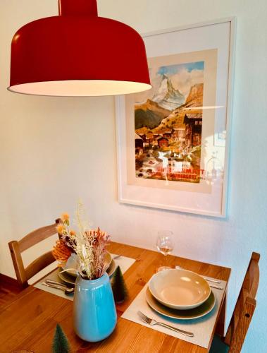 a dining room table with a red lamp and a table sidx sidx sidx at New Studio with Sunny Terrace & Air Condition in Zürich