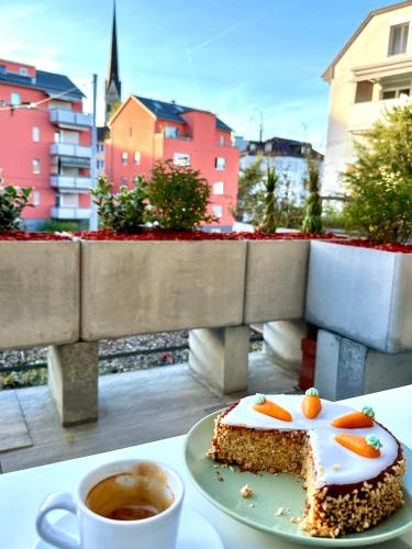 a piece of cake on a plate next to a cup of coffee at New Studio with Sunny Terrace & Air Condition in Zürich
