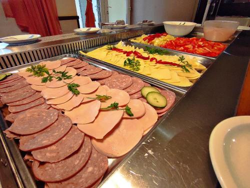 a buffet with many different types of meats and vegetables at Átrium Hotel Harkány in Harkány