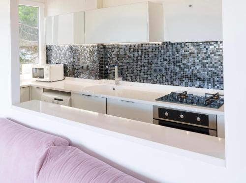 a white kitchen with a sink and a microwave at Marina Mar in Platja  d'Aro