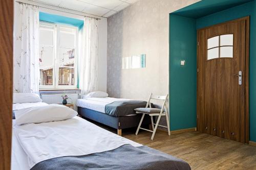 ルブリンにあるフォーク ホステルのベッド2台、ドア、窓が備わる客室です。