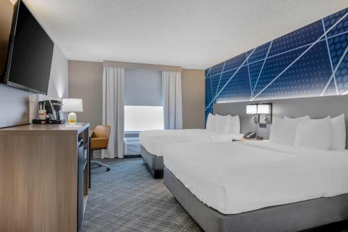a hotel room with two beds and a flat screen tv at Comfort Suites West Indianapolis - Brownsburg in Brownsburg