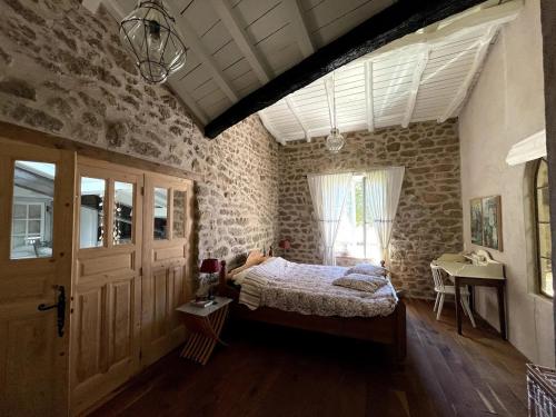 een slaapkamer met een bed en een bakstenen muur bij La Vigne, fully modernised farmhouse dated 1882 