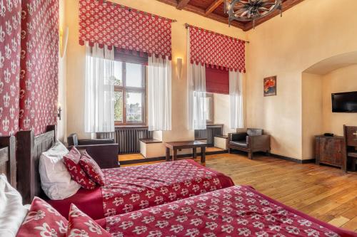 ein Hotelzimmer mit 2 Betten und einem Sofa in der Unterkunft Zamek Uniejów in Uniejów