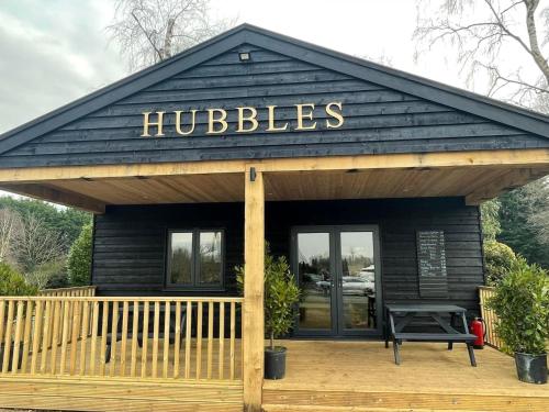 a building with a sign that reads hubbles at Wildflower Meadow Cabins in Whitington