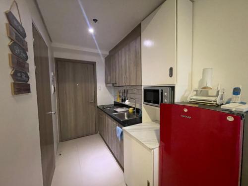 una pequeña cocina con nevera roja en una habitación en Fame Stays, en Manila