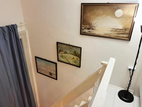 uma escada com três quadros na parede em Mimi Gallery em Budapeste