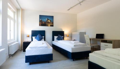 een slaapkamer met 2 bedden en een bureau bij Hanseat Apartments in Hamburg