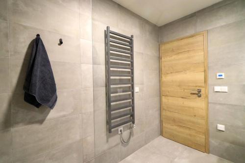 a bathroom with a shower and a wooden door at Pod Špičákem in Smržovka