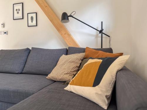 a couch with pillows on it in a living room at Pod Špičákem in Smržovka