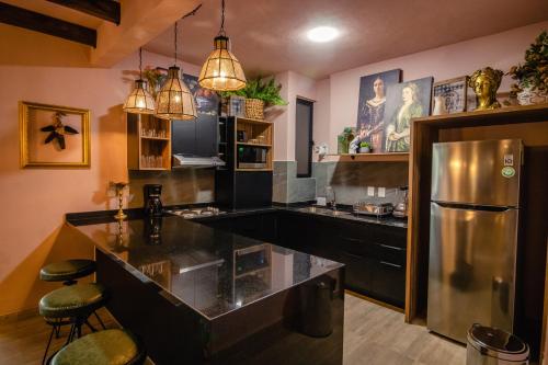 a kitchen with a stainless steel refrigerator and a counter at Casamada Residences in Guanajuato