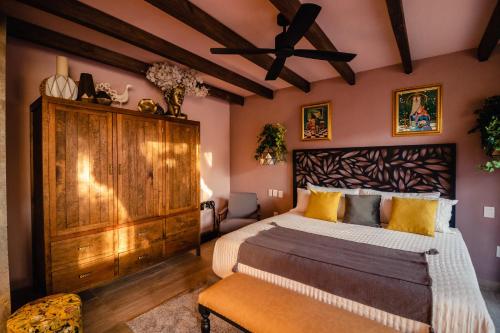 a bedroom with a large bed with a wooden headboard at Casamada Residences in Guanajuato