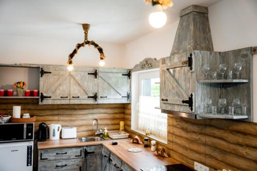 a kitchen with wooden walls and a wooden counter top at Kata Kulcsosház in Odorheiu Secuiesc