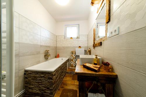 a bathroom with a tub and a sink at Kata Kulcsosház in Odorheiu Secuiesc