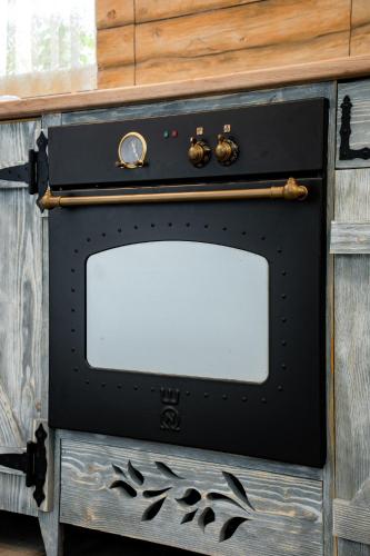 a black oven sitting inside of a wooden cabinet at Kata Kulcsosház in Odorheiu Secuiesc