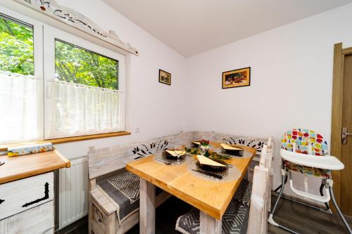 a dining room with a wooden table and chairs at Kata Kulcsosház in Odorheiu Secuiesc